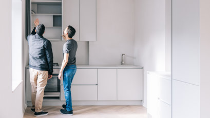 Two men looking at a cabinet